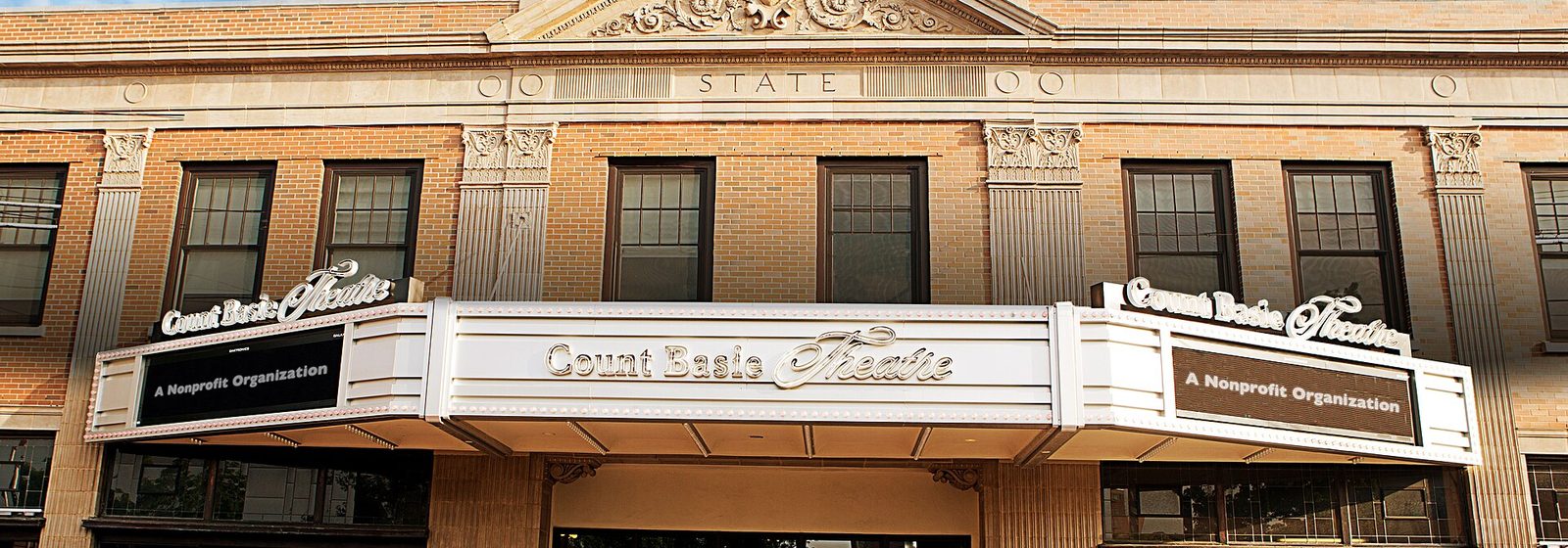 Exterior brick facade and lit marquee of the historic Count Basie Theatre, now the Hackensack Meridian Health Theatre at the Count Basie Center for the Arts, with patrons gathered at the entrance in Red Bank, New Jersey - Hackensack Meridian Health Theatre at the Count Basie Center for the Arts tickets