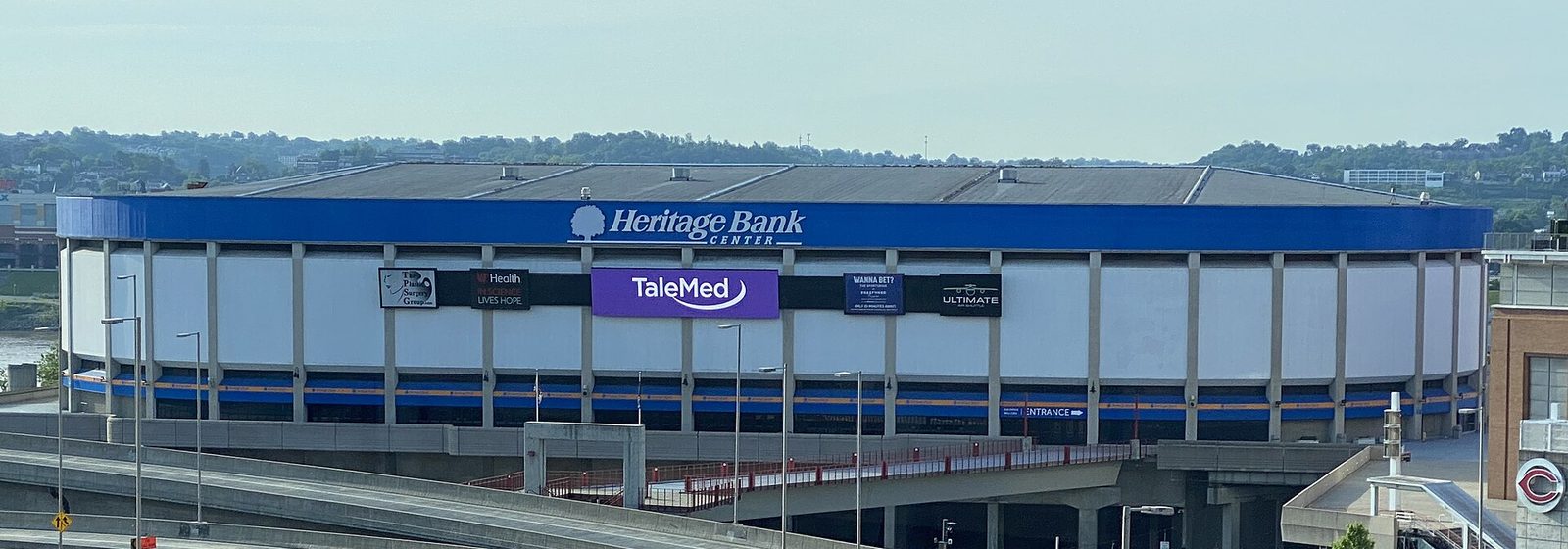 Wide exterior view of Heritage Bank Center's curved facade and blue roofline on the downtown Cincinnati riverfront - Heritage Bank Center tickets