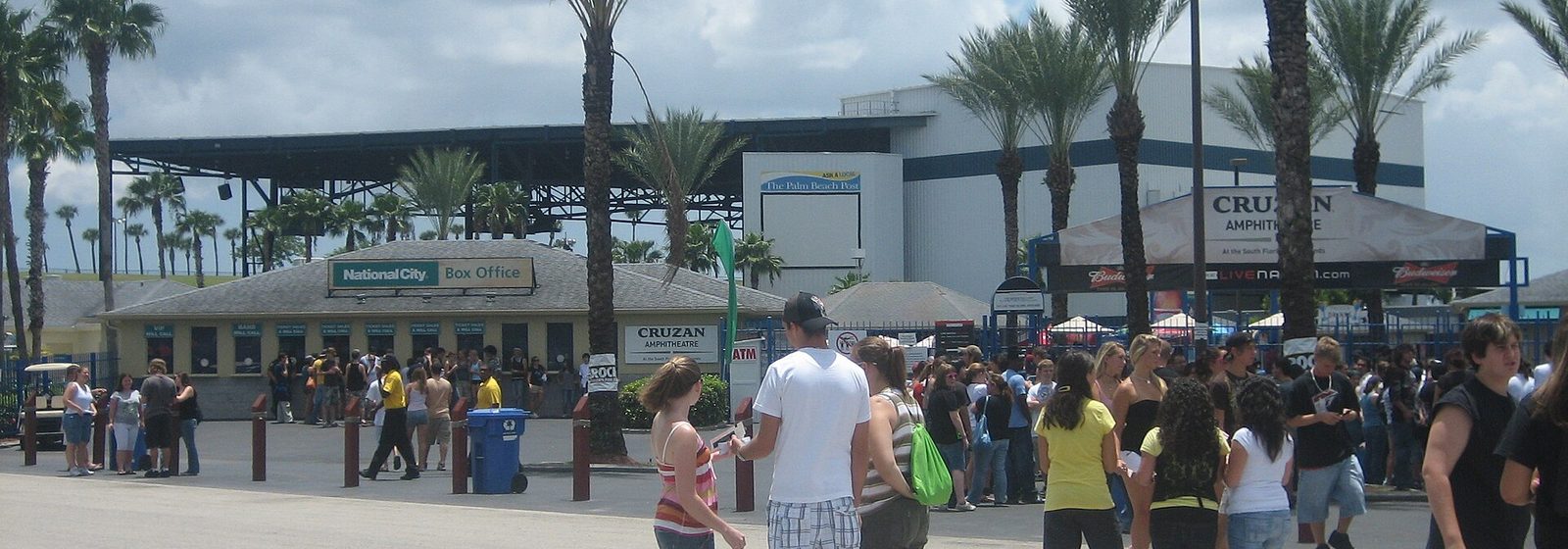 Concertgoers outside the north entrance and box office of iTHINK Financial Amphitheatre (then Sound Advice Amphitheatre) in West Palm Beach, with the venue's roof canopy and stage house behind - iTHINK Financial Amphitheatre tickets