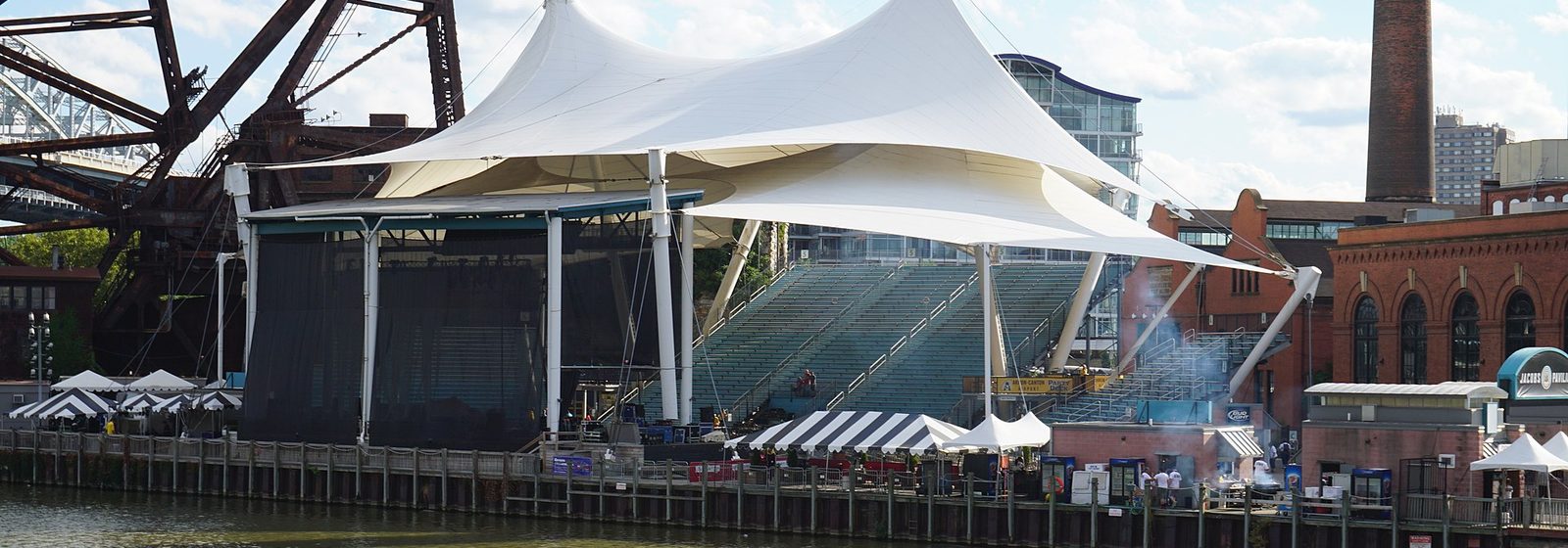 View across the Cuyahoga River of the white tent-roofed Jacobs Pavilion amphitheater on the West Bank of the Flats in Cleveland, Ohio - Jacobs Pavilion tickets