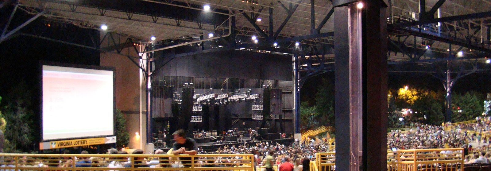 Covered pavilion seating and roof structure inside Jiffy Lube Live (then Nissan Pavilion) in Bristow, Virginia, during a night concert - Jiffy Lube Live tickets
