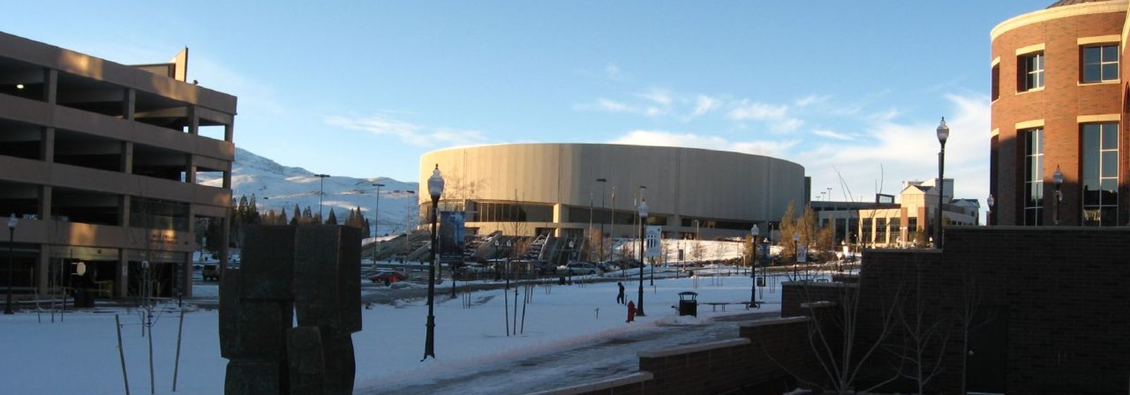 Winter exterior view of the round Lawlor Events Center arena on the University of Nevada, Reno campus, seen across a snow-covered plaza - Lawlor Events Center tickets