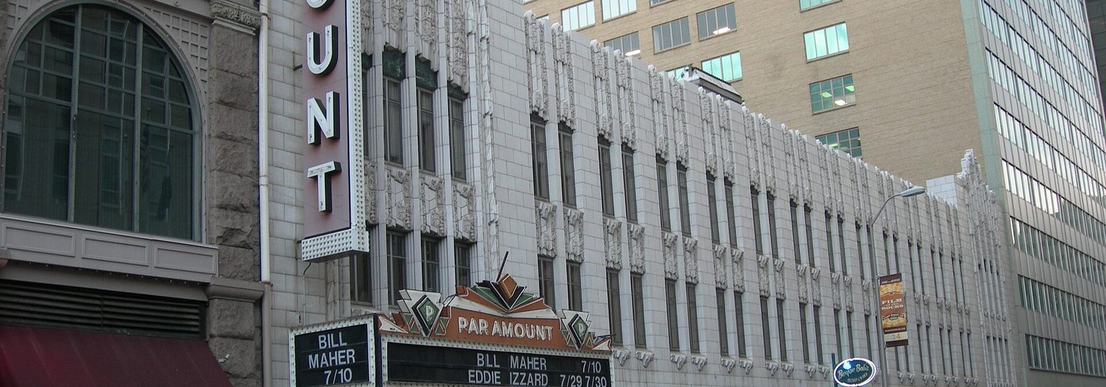 Street-level view of the Paramount Theatre's terra-cotta facade, vertical Paramount blade sign, and marquee on Glenarm Place in downtown Denver - Paramount Theatre - Denver tickets