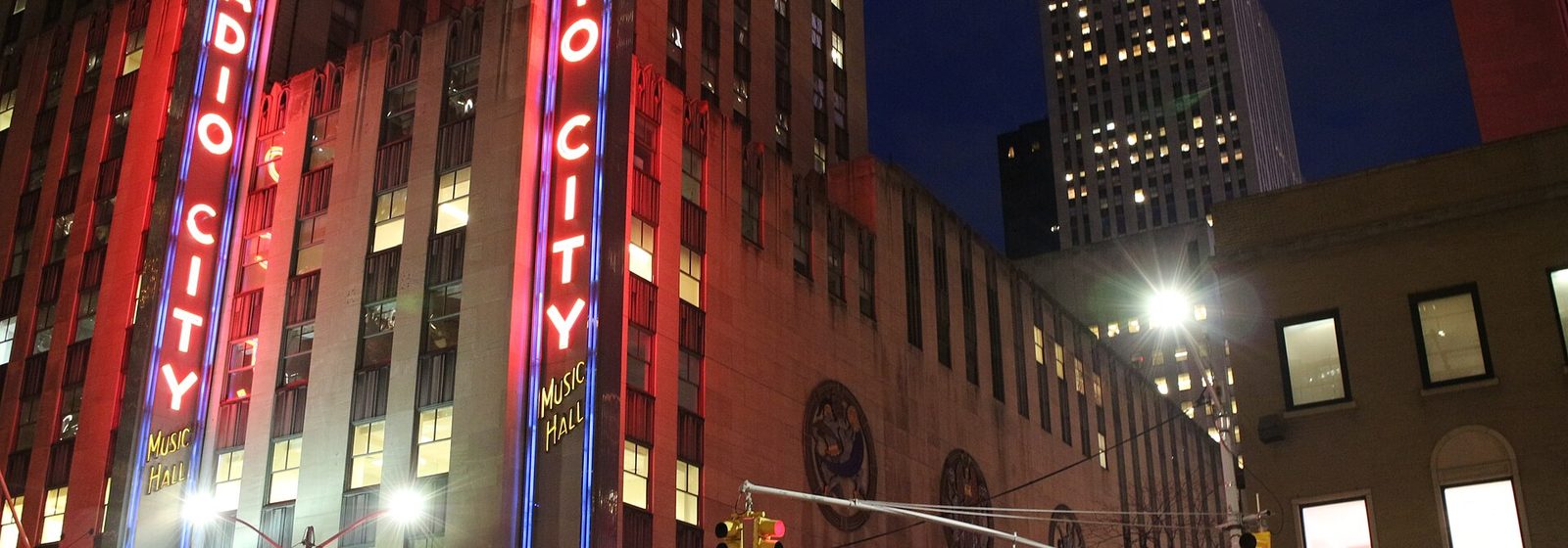 Night view of the Radio City Music Hall exterior and its illuminated neon marquee on Sixth Avenue in Midtown Manhattan, New York - Radio City Music Hall tickets