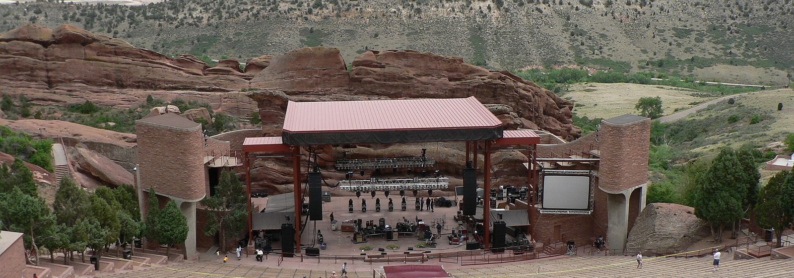 View from the upper rows of Red Rocks Amphitheatre in Morrison, Colorado, looking down the seating bowl to the stage set between red sandstone rock formations - Red Rocks Amphitheatre tickets