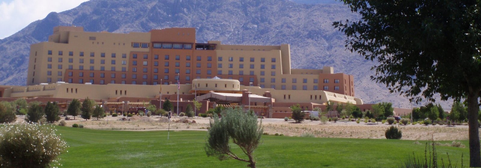 Exterior of the Sandia Resort & Casino complex, home of the Sandia Casino Amphitheater, with the Sandia Mountains rising behind it in Albuquerque, New Mexico - Sandia Casino Amphitheater tickets