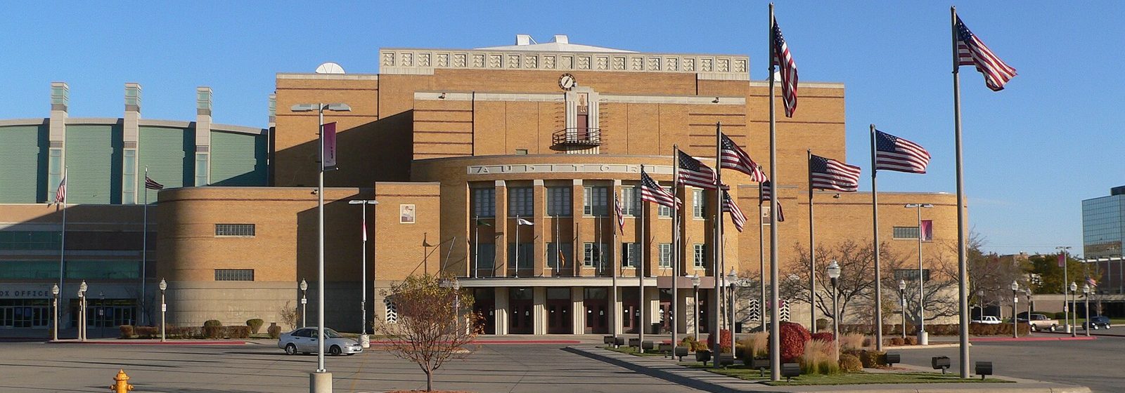 Exterior view from the south of the Sioux City Municipal Auditorium in Sioux City, Iowa, with a row of flagpoles in front of its brick Art Deco facade - Sioux City Auditorium tickets