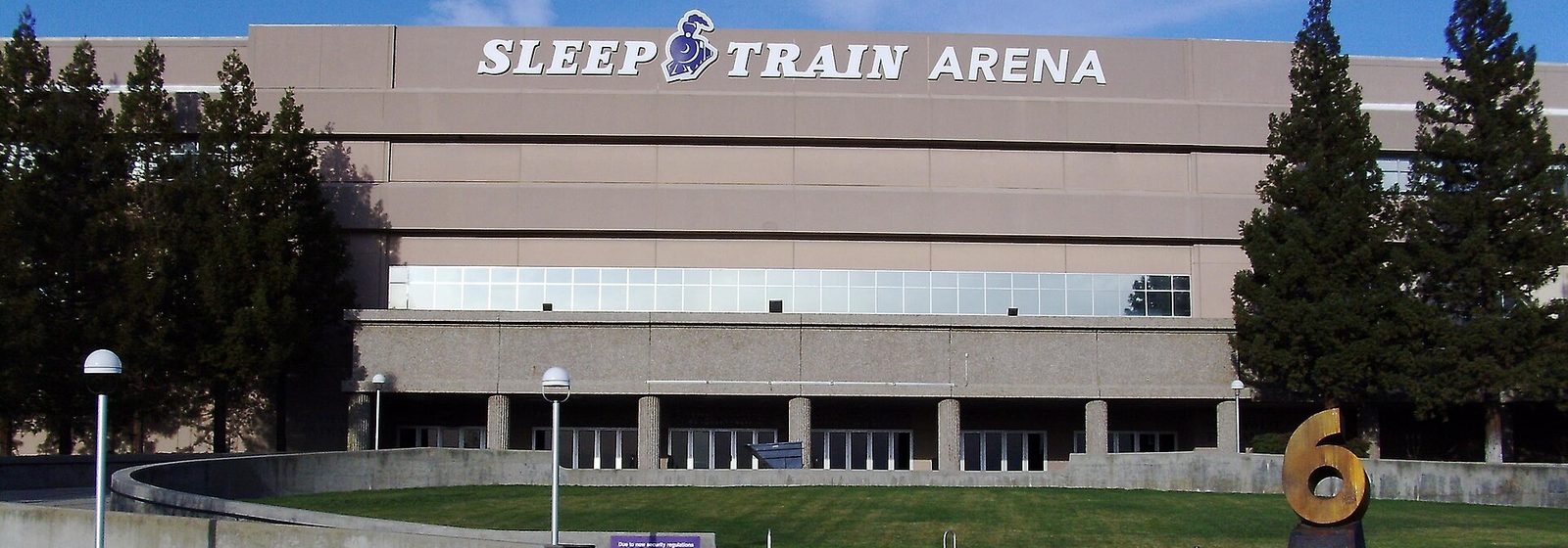 Exterior view of Sleep Train Arena in Sacramento, California, showing the arena's name on its tan facade above the entrance lawn - Sleep Train Arena tickets