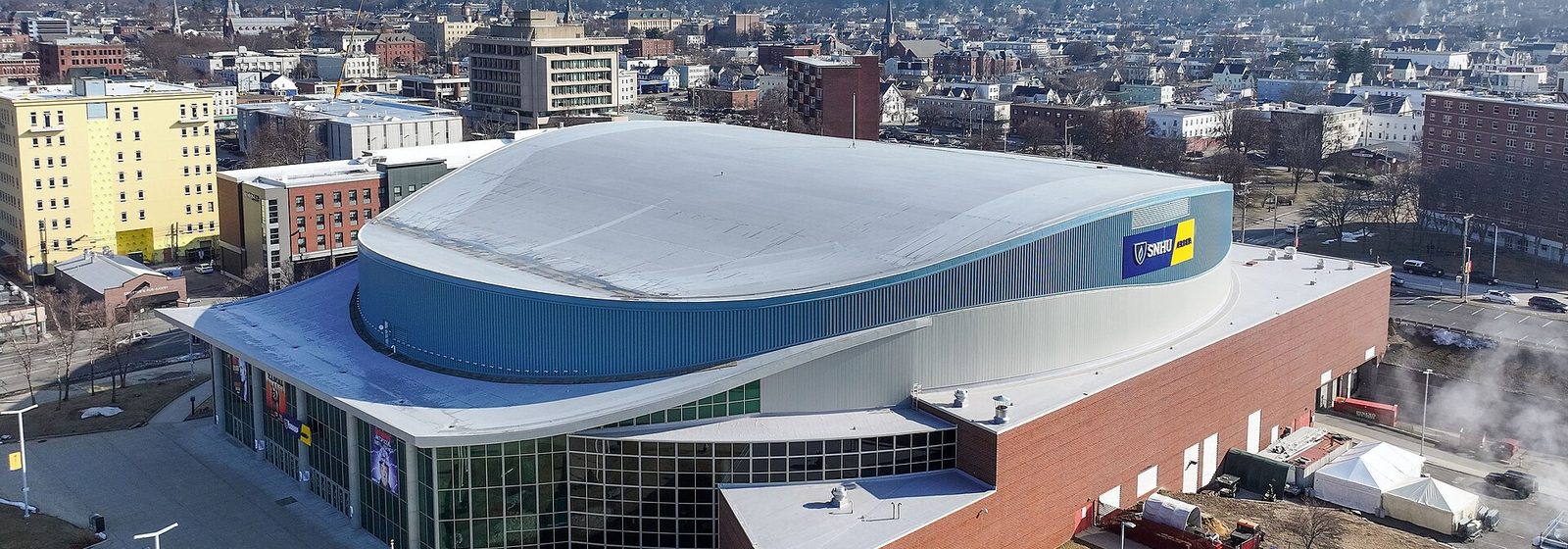 Aerial view of SNHU Arena's oval roof and brick facade in downtown Manchester, New Hampshire - SNHU Arena tickets
