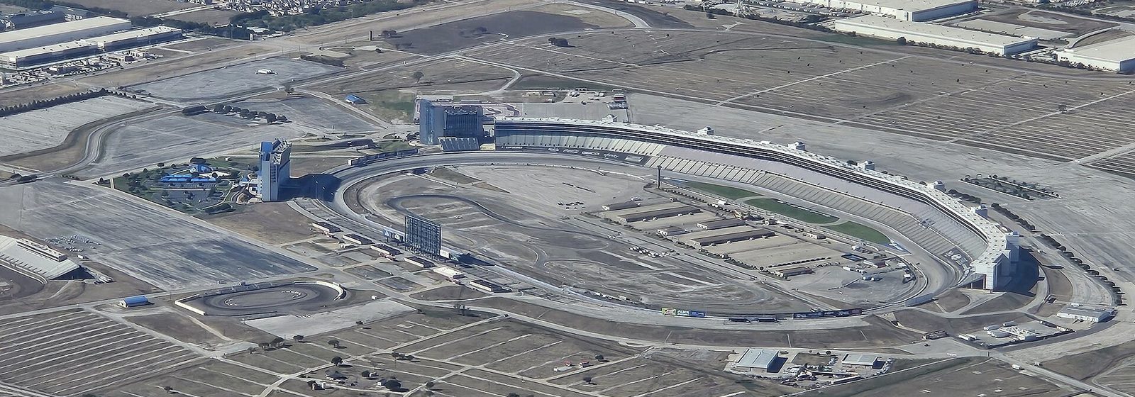 Aerial view of the Texas Motor Speedway oval track, grandstands, and surrounding parking lots in Fort Worth, Texas - Texas Motor Speedway tickets