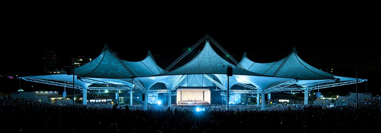 Wide night view of The Cynthia Woods Mitchell Pavilion's illuminated tent-canopy roof during a concert in The Woodlands, Texas - The Cynthia Woods Mitchell Pavilion tickets