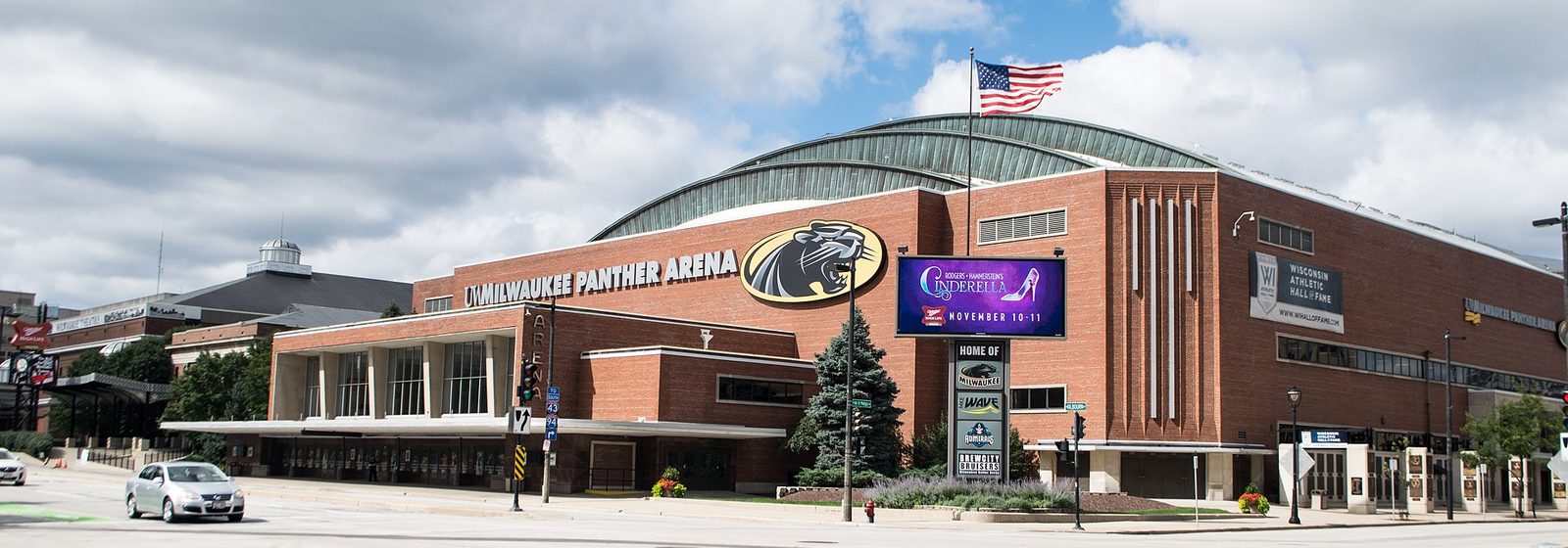 Exterior view of the UWM Panther Arena in downtown Milwaukee, Wisconsin, with flags flying near its entrance - UWM Panther Arena tickets
